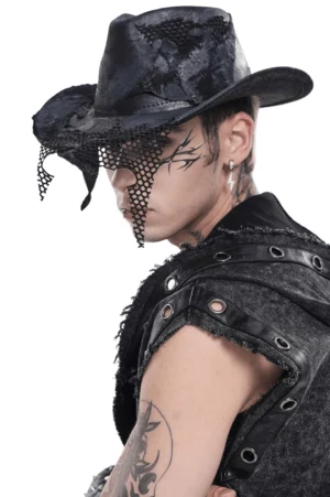 Black gothic cowboy hat with distressed mesh patch details, left profile view on tattooed male model