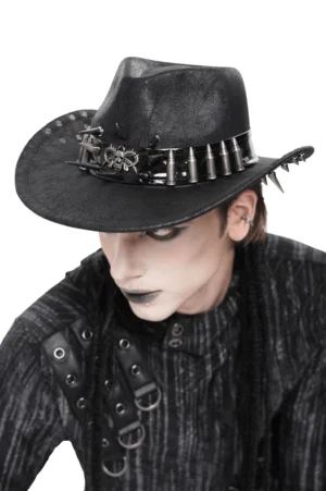 Three-quarter front view of gothic cowboy hat with prominent skull centerpiece and spike-studded metal band on male alternative model