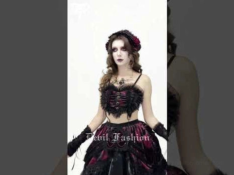 Female model wearing complete black mesh gothic heart bustier crop top with burgundy velvet accents, styled with goth accessories and dark fashion aesthetic