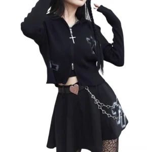 Gothic cropped zipper sweater styled with black pleated skirt, heart chain belt and fishnet stockings, side view