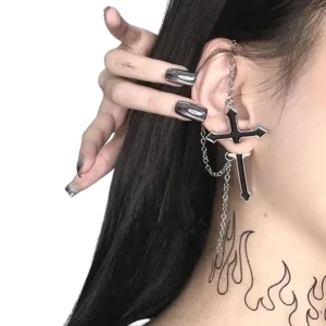 Gothic cross chain earrings worn by woman with dark hair styled for alternative fashion close-up side view showing chain tassels