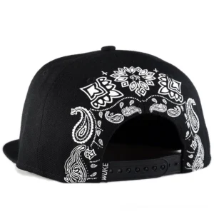 Black gothic snapback cap rear view showing adjustable snap buckle closure and white paisley embroidery pattern