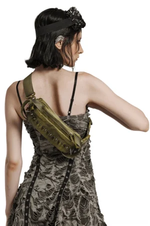 Spiked gothic shoulder bag worn on back by alternative model, back sling carry style, olive faded nylon with metal spike decoration