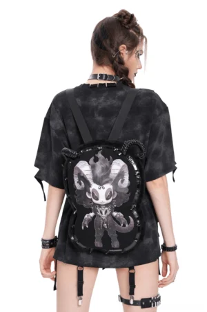 Female model wearing gothic demon plush backpack with metal horns and spikes, rear full view in alternative punk outfit