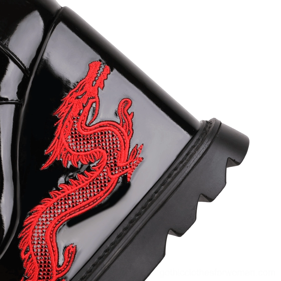 Close-up detail of red dragon embroidery on black patent leather gothic platform boot heel