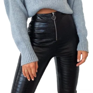 High-waist black faux leather pencil pants with crocodile texture and front O-ring zipper, worn on female model showing side profile and leg fit