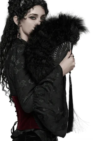 Gothic black feather hand fan with cross tassel pendant held by model in profile view, worn with dark embroidered corset