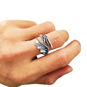Adjustable gothic ring worn on male model's hand, demonstrating open wrap fit and wing texture detail with silver tone