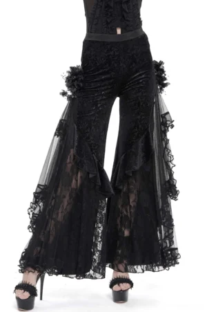 Black gothic flocked wide leg pants front view with lace ruffled sides and 3D floral flower decorations on female model