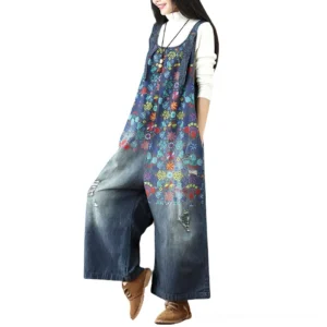 Floral denim wide-leg overalls with distressed details, shown on model from left three-quarter angle, featuring botanical print panels and authentic vintage styling