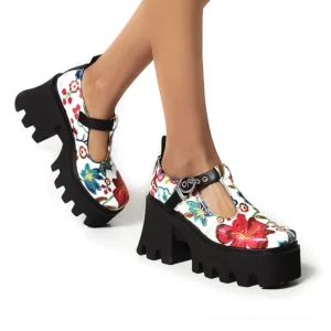 Woman wearing black floral gothic platform Mary Jane pumps with white floral print and T-strap buckle, shown from side angle in studio