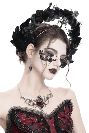 Black gothic halo crown with cross and beaded chain worn by model at three-quarter angle with dark lipstick