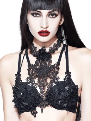 Close-up detail of black gothic lace harness showing intricate lace carving and gem-like 3D flower embellishments on chest panel