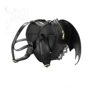 Black gothic heart backpack rear view showing dual gold metal zippers, adjustable shoulder straps, and bat wing silhouette against dark background