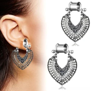 Single gothic heart tunnel earring with intricate filigree carving worn on female ear, side close-up view