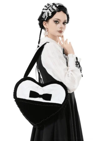 Female model wearing black heart-shaped gothic lace bow crossbody bag with gothic lolita maid-style outfit showing back side profile styling