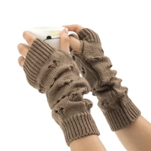 Khaki gothic hollow heart fingerless arm warmers displayed on hands with white mug, showing detailed heart cutout design and ribbed cuff