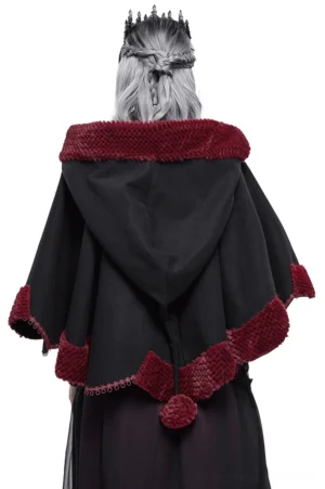 Back view of black gothic short cape with wine red pompom and scalloped fuzzy hem on model with silver hair