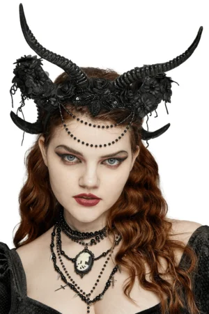 Black gothic horned headpiece with lace flowers and beaded forehead chain worn by model, frontal portrait view on white studio background