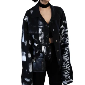 Cropped graffiti denim jacket detail showing flap chest pockets and artistic lettering prints on black denim