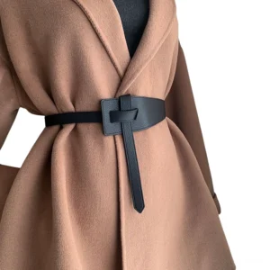 Black knotted PU leather belt with long tail strap worn with camel wool wide coat, waist close-up front view showing gothic minimalist styling