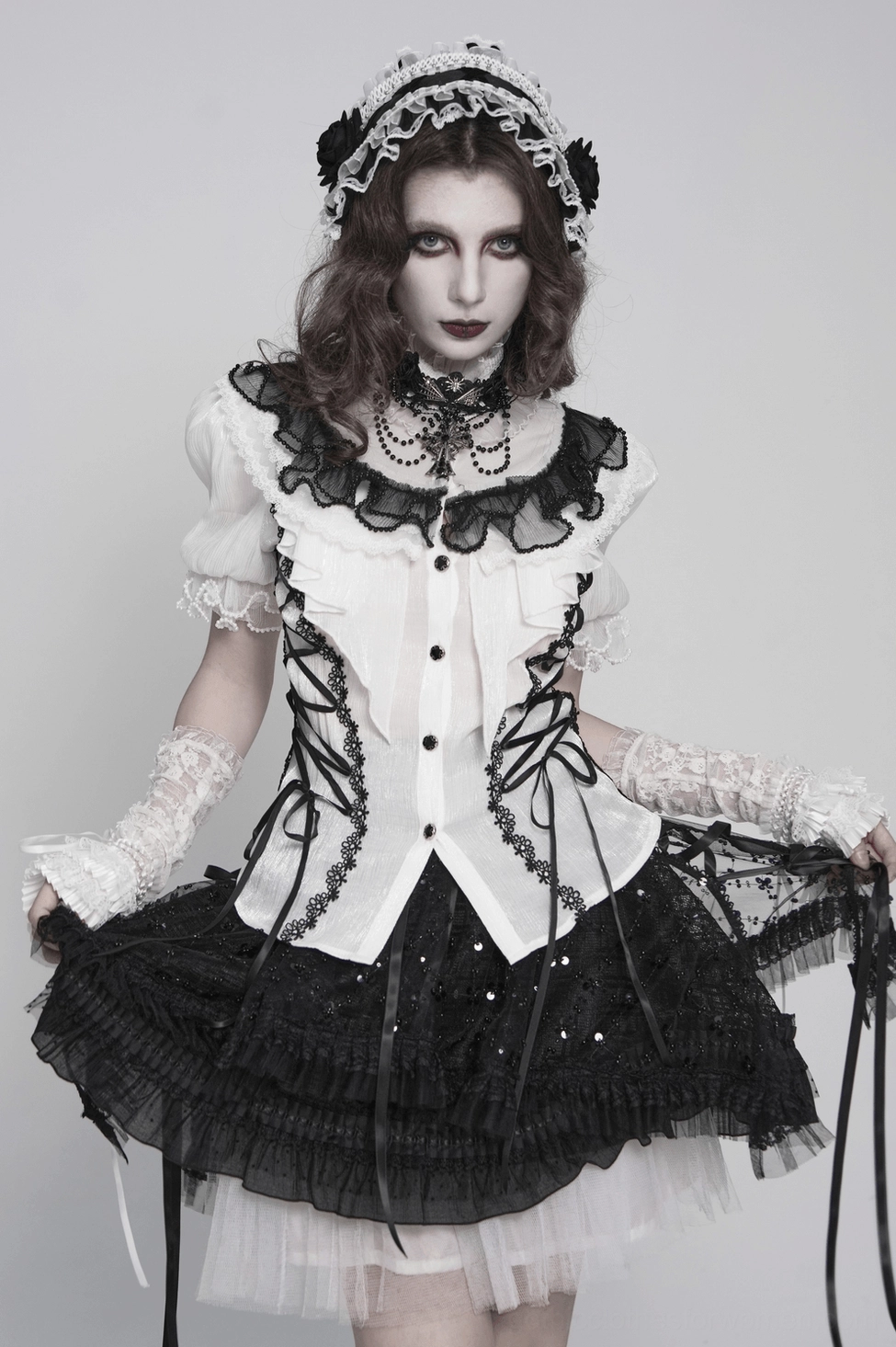 Side angle shot of black and white gothic lolita lace bonnet showing structured silhouette and ribbon ties
