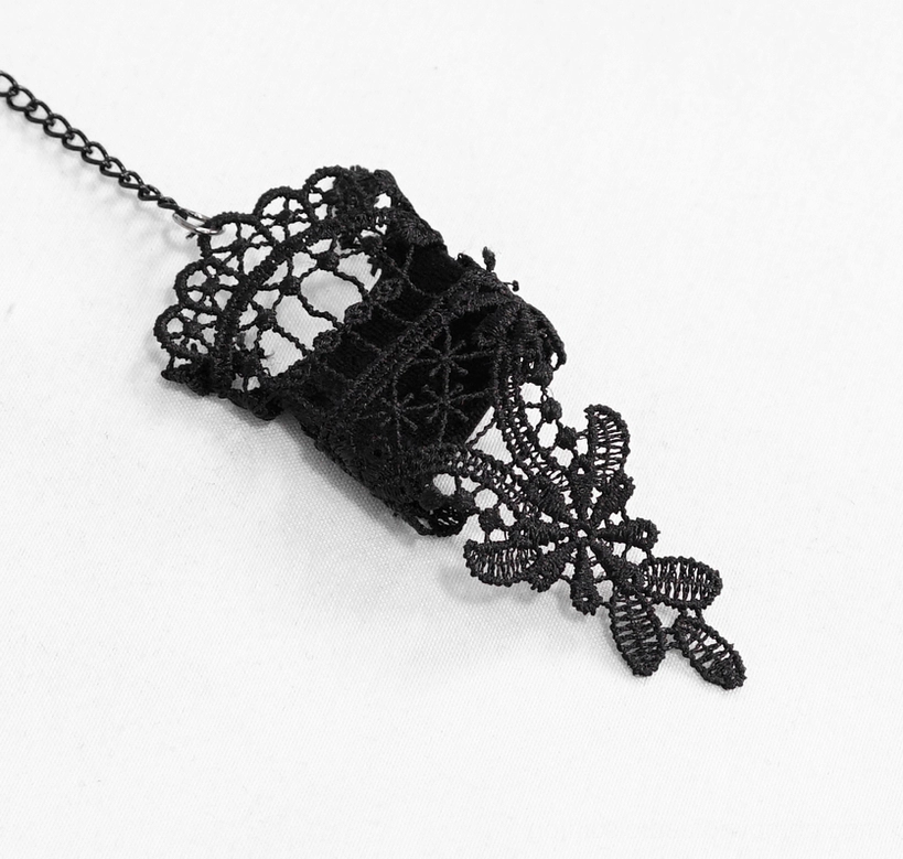 Black gothic lace finger sleeve accessory with floral lace pattern and chain tassel detail in flat lay