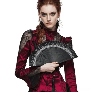 Red-haired gothic model wearing elegant black lace carved hand fan in studio setting, front view showcase of intricate lace design
