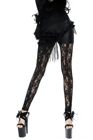Black lace gothic leggings with PU leather waist and tassel fringe, side view on model with studio background