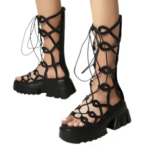 Black platform sandals with intricate crisscross lace straps and serrated sole, front overhead view