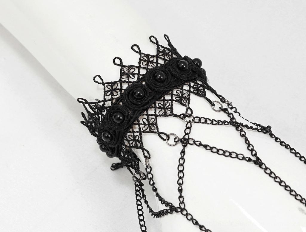 Gothic lace slave bracelet with decorative studs on lace band displayed on white mannequin hand