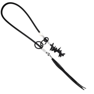 Flat lay overhead view of gothic lariat necklace with detachable tassel and spike pendants, black rubber cord with silver metal fittings