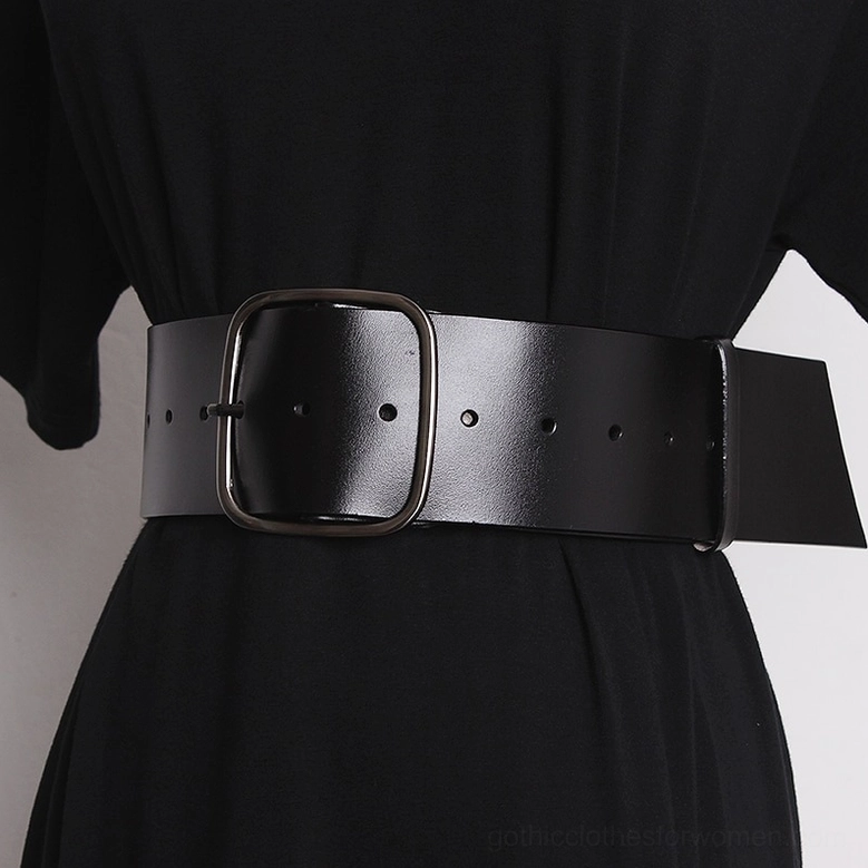 Wide black leather belt with gunmetal square buckle worn as corset accessory on black dress, studio shot
