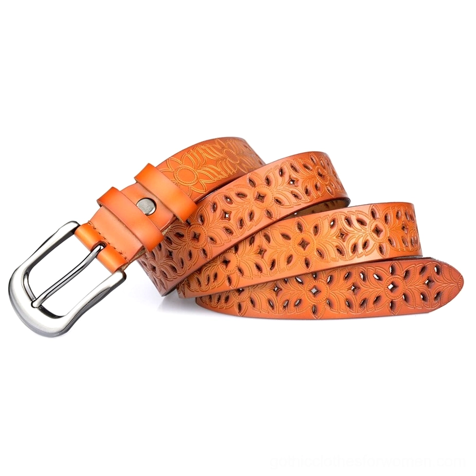 Bright orange stacked hollow-carved leather gothic belts showing the intricate floral pattern and silver pin buckle hardware