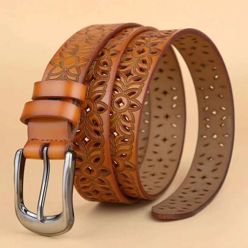 White leather gothic belt with gunmetal pin buckle showing the symmetrical hollow-carved floral pattern and strap construction