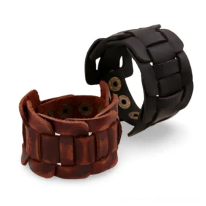 Black and brown genuine leather gothic cuff bracelet with snap fasteners, frontal flat lay view on white background