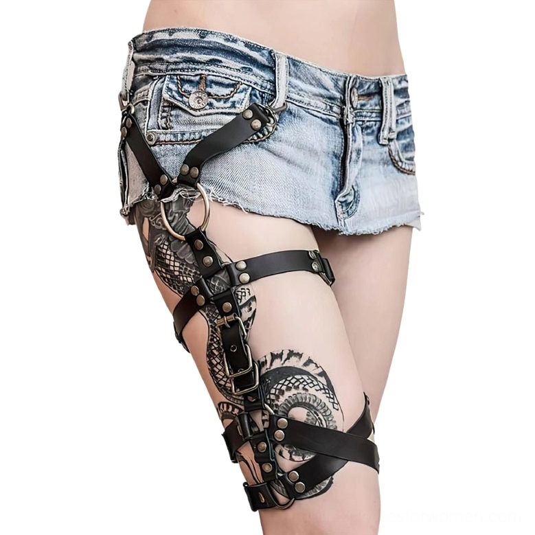 Black synthetic leather thigh harness belt with metal rivets and O-rings, side profile view on tattooed model