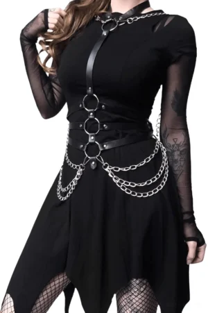 Black PU leather harness with multiple O-rings and chains shown on model wearing fishnet stockings and irregular hem dress, side perspective