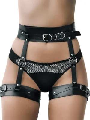 Black synthetic leather leg garter body harness belt with silver hardware displayed on model against white studio background