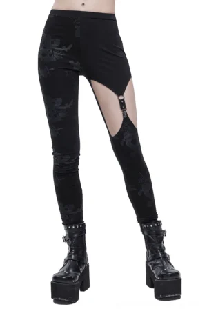 Black asymmetrical gothic leggings with horror print and metal thigh buckle cutout worn by model, front three-quarter view
