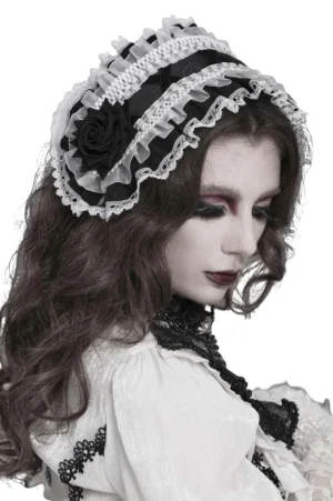 Black and white gothic lolita lace bonnet with black rose accent shown on model in side profile view
