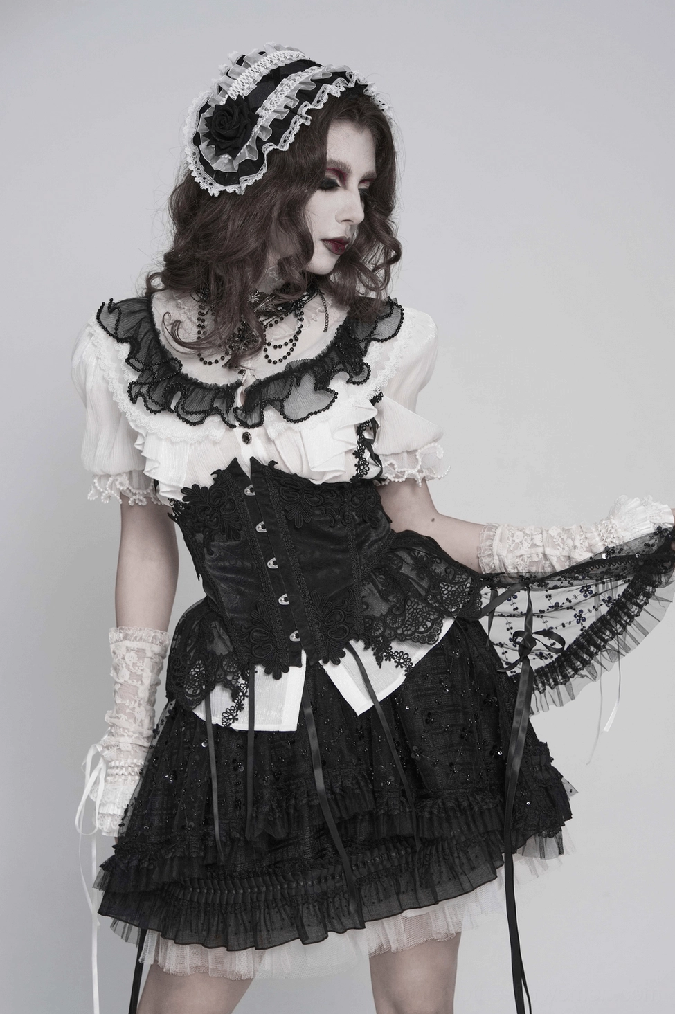 Three-quarter front view of black and white gothic lace bonnet with full silhouette display on model