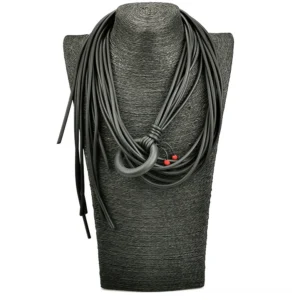 Multi-strand wrapped gothic necklace displayed on fabric dress form - dark grey background showing matte black rubber texture and knotted ring fastening