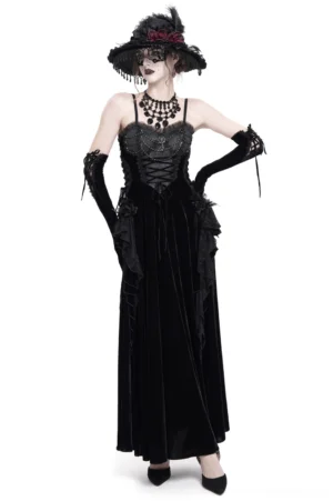 Black velvet gothic maxi dress with lace-up corset front, beaded chain necklace, and long gloves worn by model in studio setting