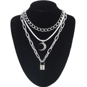 Multi-layered silver gothic chain necklace with crescent moon and lock pendants displayed on black mannequin, front view showcase