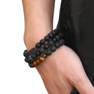Multi-strand black stone gothic bracelet with crown ornament styled on arm with leather jacket, alternative jewelry showcase