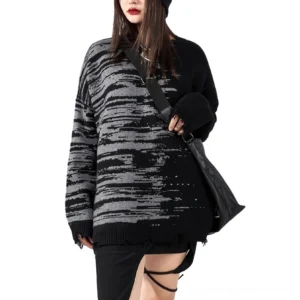 Black distressed gothic oversized knit sweater front three-quarter view worn by female model in studio with brush pattern details and frayed hem