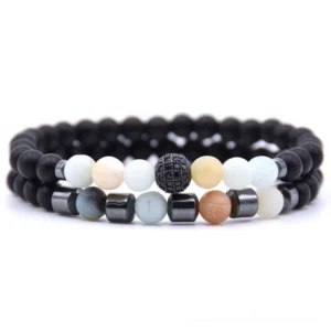 Gothic paired stone bead bracelets with black matte beads, earth tone accents, and paved bead charm detail in flat lay
