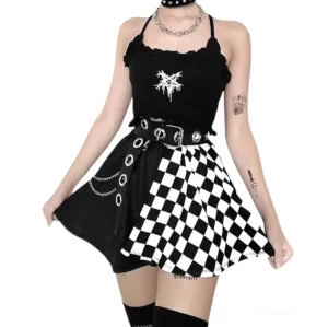 High-waist checkerboard and black patchwork mini skirt front view on model with layered jewelry, showing eyelet trim and chain decor details