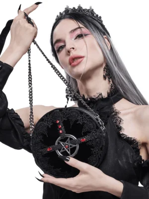 Gothic pentagram round shoulder bag held by model wearing crown, featuring black lace and red gem accents, studio fashion photography